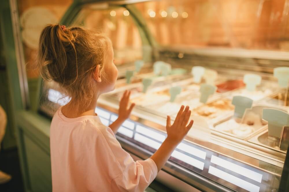 A little girl looking at ice cream at a Panama City Beach spot.